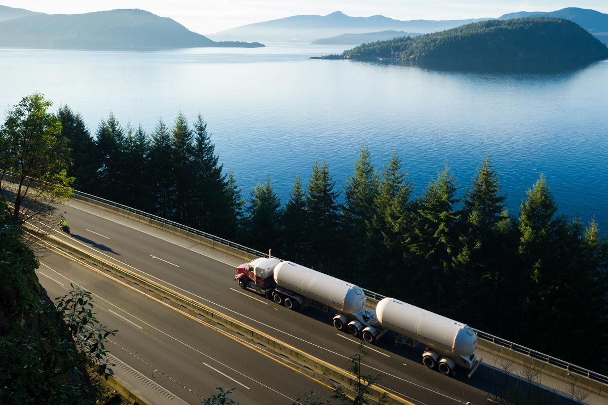 Truck and trailer with tank container drive along the highway